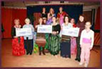 Group of dancers with giant cheques Group of dancers with giant cheques
